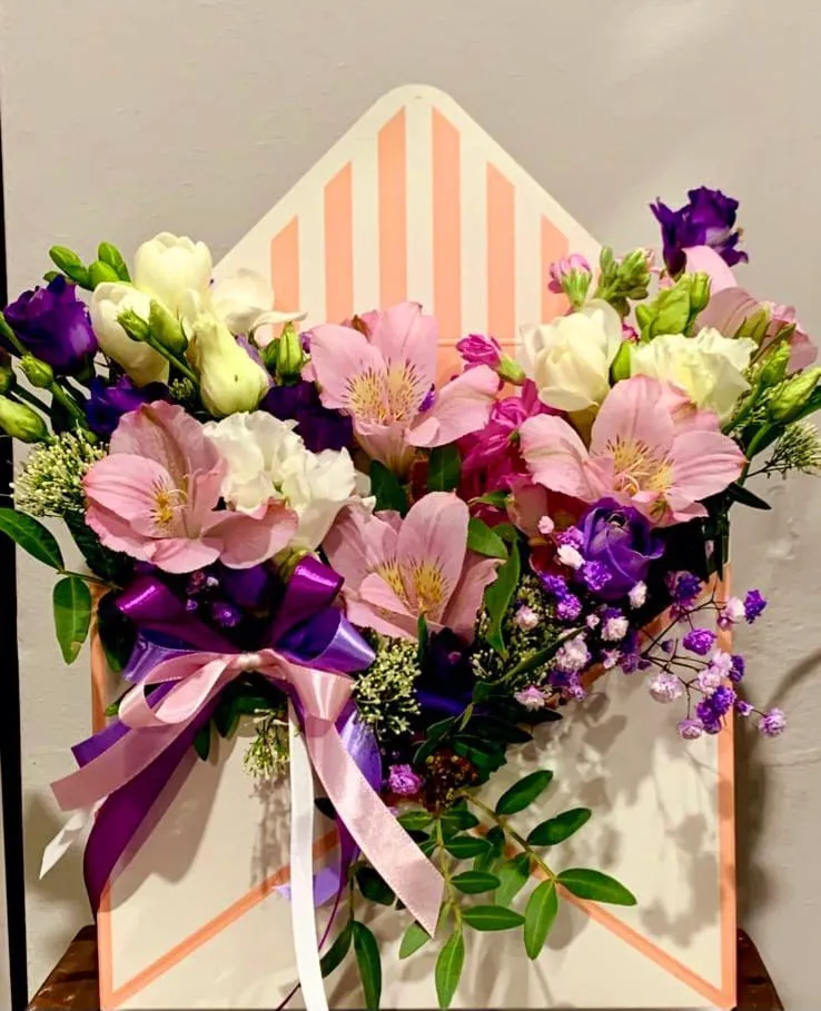 Ziedu kompozīcija aploksnes formas kastē ar lillā lenti